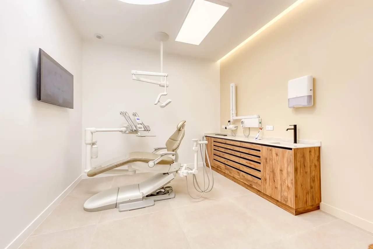 Salle de soins lumineuse du Cabinet Dentaire Chasles avec fauteuil et plan de travail en bois